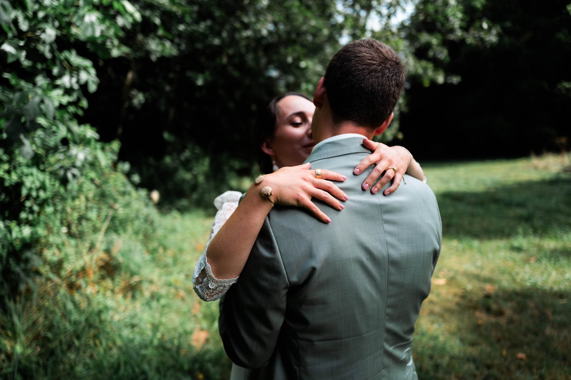 Deux mariés s’enlaçant tendrement dans un jardin verdoyant.