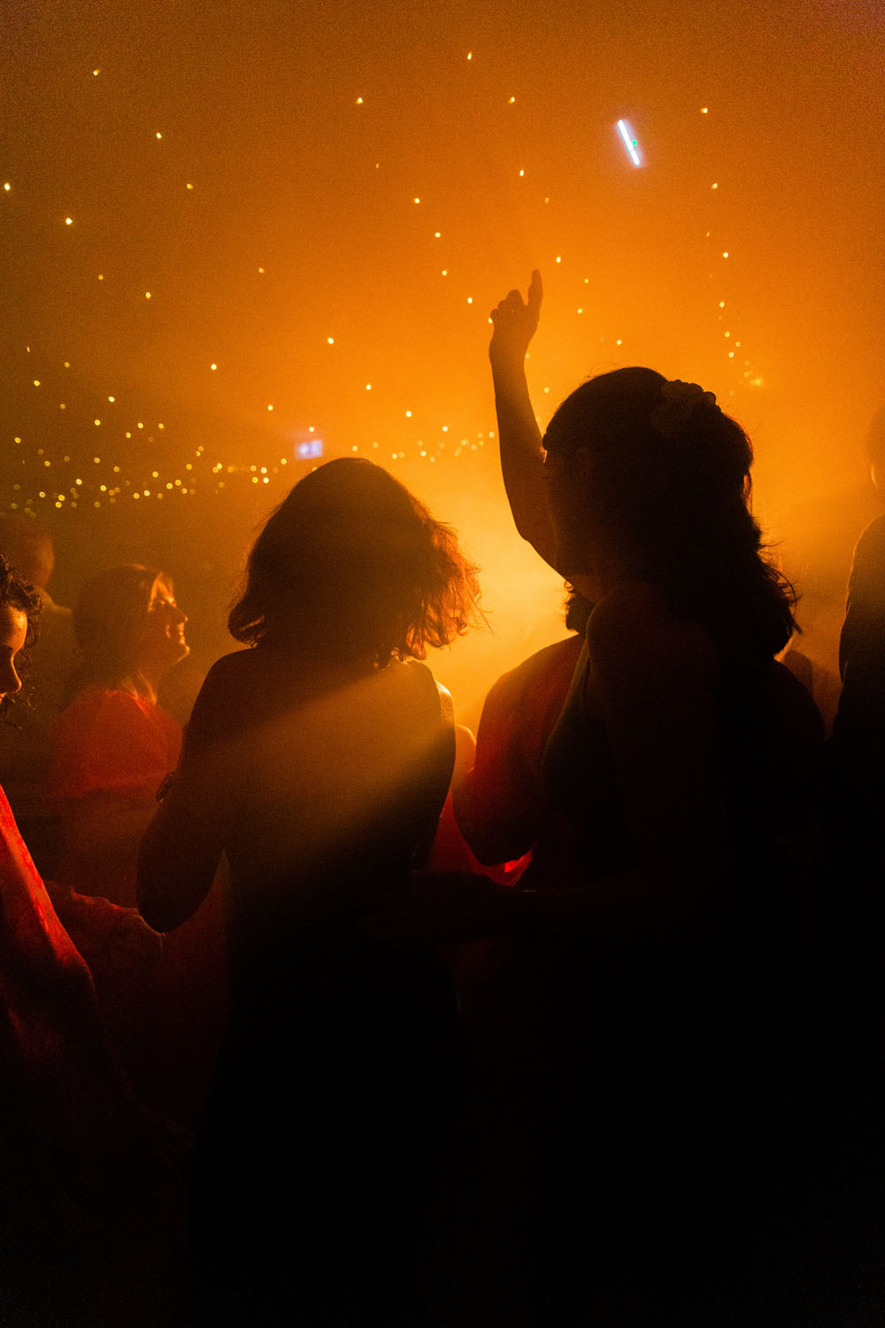 Invités dansant sur une piste de mariage éclairée par des lumières chaudes et une ambiance festive.